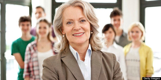 Female mature teacher with students in background