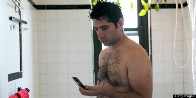 Man in bathroom looking at phone
