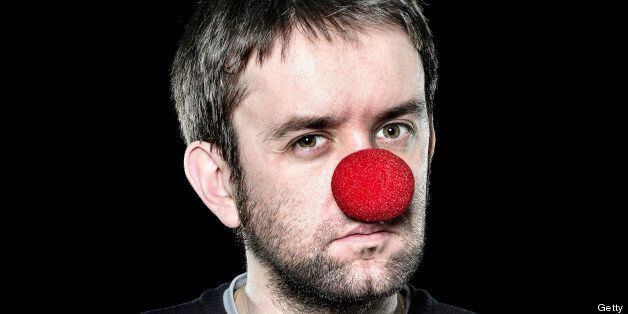 Serious man with red nose on black background