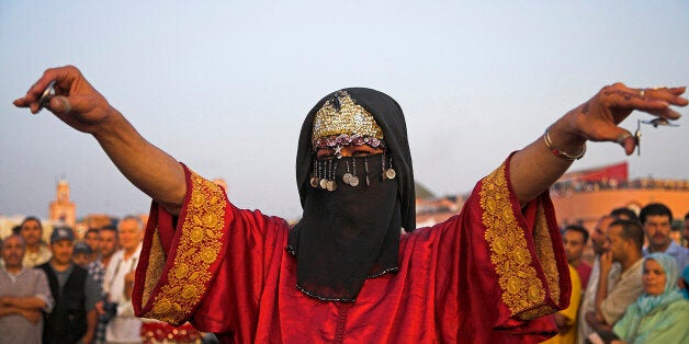 Morocco, A traditional transvestite dancer performs in the Djemaa el Fna, Marrakech, Morocco.