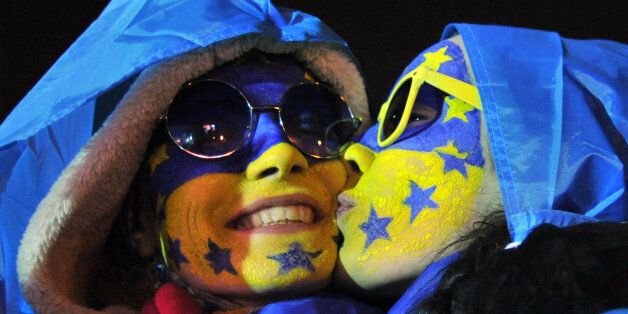 Young protesters with faces painted in colors of Ukrainian and EU flags kiss each other early on December 4, 2013 at a tent camp on Independence Square in Kiev. Ukraine's opposition called on December 3 for sustained pressure from the street after days of protests that have plunged the country into its biggest crisis in nearly a decade, as the government survived a no-confidence vote in parliament. AFP PHOTO/GENYA SAVILOV (Photo credit should read GENYA SAVILOV/AFP/Getty Images)