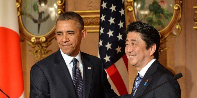 US President Barack Obama (L) shakes hands with Japanese Prime Minister Shinzo Abe following a bilateral press conference at the Akasaka Palace in Tokyo on April 24, 2014. Obama told a press conference in Japan that islands at the centre of a bitter territorial dispute with China are covered by a defence treaty that would oblige Washington to act if they were attacked. AFP PHOTO / KAZUHIRO NOGI (Photo credit should read KAZUHIRO NOGI/AFP/Getty Images)