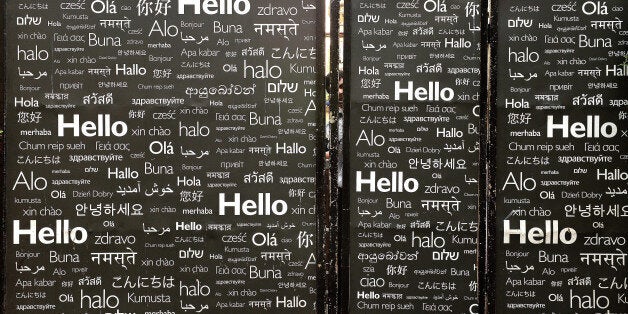 A security guard is seen behind a side entrance of a hotel decorated with the greeting 'Hello' in various languages in Mumbai on January 3, 2014. AFP PHOTO/ INDRANIL MUKHERJEE (Photo credit should read INDRANIL MUKHERJEE/AFP/Getty Images)