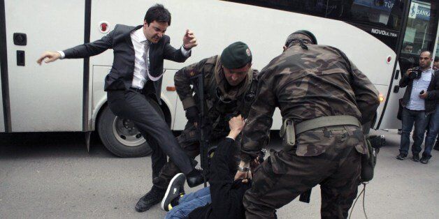 Photo taken on May 14, 2014shows a person identified by Turkish media as Yusuf Yerkel, advisor to Turkish Prime Minister Recep Tayyip Erdogan, kicking a protester already held by special forces police members during Erdogan's visit to Soma, Turkey. Erdogan was visiting the western Turkish mining town of Soma after Turkey's worst mining accident . AFP Photo/Depo Photos (Photo credit should read DEPO PHOTOS/AFP/Getty Images)