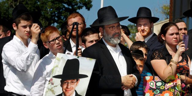 A photograph of Aaron Sofer, 23, is nearby as people listen during a news conference Tuesday, Aug. 26, 2014, in Lakewood, N.J. Israeli police said Tuesday they are searching for the young New Jersey religious student who went missing during a hike in a forest outside Jerusalem last week. Sofer of Lakewood, New Jersey, has been missing since Friday when he went on a hike with a friend in the Jerusalem Forest, said police spokesman Micky Rosenfeld. Rosenfeld said that police have launched an extensive search for Sofer, who is an ultra-Orthodox student at a yeshiva â a Jewish religious school. Sofer's parents have flown to Israel. (AP Photo/Mel Evans)