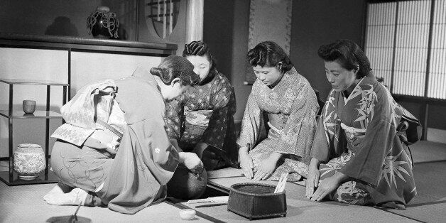 Seated on tatamis (straw mat), these women go through the traditional Japanese tea ceremony in Japan on Dec. 18, 1947, attired in kimonos. The hostess pulls the pot of boiling water from under the floor where its has been heated by charcoal, while the guest show their appreciation by the attitude of their hands and posture. (AP Photo)