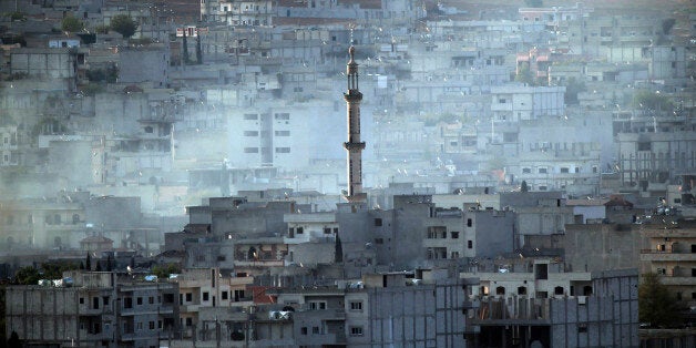 Smoke rises following a strike in Kobani, Syria while fighting continued between Syrian Kurds and the militants of Islamic State group, as seen from Mursitpinar on the outskirts of Suruc, at the Turkey-Syria border, Wednesday, Oct. 15, 2014. Kobani, also known as Ayn Arab, and its surrounding areas, has been under assault by extremists of the Islamic State group since mid-September and is being defended by Kurdish fighters. (AP Photo/Lefteris Pitarakis)