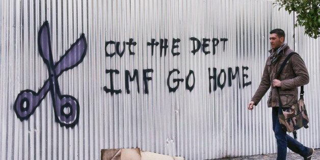ATHENS, GREECE - FEBRUARY 10: A citizen passes by graffiti against the IMF on February 10, 2015 in Athens, Greece. The new Gr