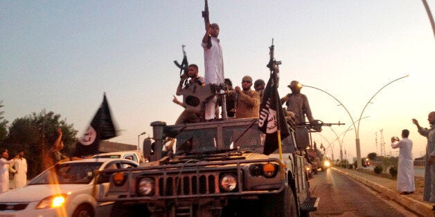 FILE - In this photo taken Monday, June 23, 2014, fighters from the Islamic State group parade in a commandeered Iraqi security forces armored vehicle down a main road at the northern city of Mosul, Iraq. Islamic State militants have abducted at least 70 Assyrian Christians, including women and children, after overrunning a string of villages in northeastern Syria, two activist groups said Tuesday, Feb. 24, 2015. (AP Photo/File)