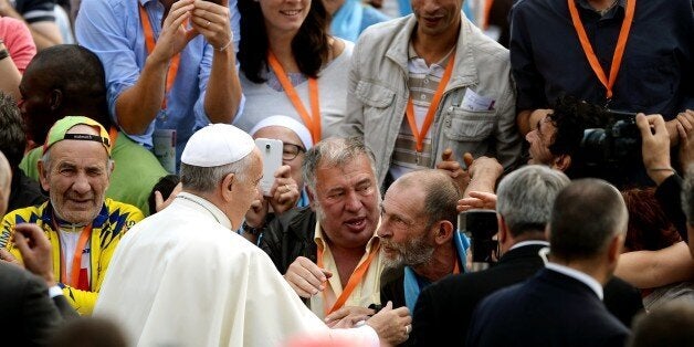 French homeless from different French cities, shake hands with Pope Francis upon his arrival for his weekly general audience in St Peter's square at the Vatican on October 22, 2014. AFP PHOTO / FILIPPO MONTEFORTE (Photo credit should read FILIPPO MONTEFORTE/AFP/Getty Images)