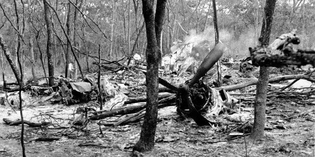 FILE - In this Sept. 19, 1961 file photo, searchers walk through the scattered wreckage of the DC6B plane in a forest near Ndola, Zambia. Fifty years after the plane carrying U.N. Secretary-General Dag Hammarskjold crashed in the African bush during a peace mission to Congo, killing all aboard, the accident remains one of the Cold War's greatest unsolved mysteries. (AP Photo)