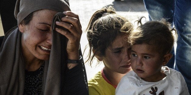 Relatives of wounded people react in front of the hospital of Suruc, Sanliurfa province, on June 25, 2015 after a deadly suicide bombing occurred in the Syrian town of Kobane, accross the border with Turkey, killing 12 civilians. Turkey denied 'baseless' claims that Islamic State (IS) militants reentered the Syrian town of Kobane, also known as Ain al-Arab, through the Turkish border crossing to detonate a suicide bomb. AFP PHOTO / ILYAS AKENGIN (Photo credit should read ILYAS AKENGIN/AFP/Getty Images)