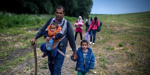 A group of migrants from Syria walk towards the border with Hungary, near the northern Serbian village of Martonos, near Kanjiza, on June 25, 2015.Hungary said it has indefinitely suspended the application of a key EU asylum rule in order 'protect Hungarian interests', prompting Brussels to seek immediate clarification. Illegal immigrants cross Serbia on their way to other European countries as it has land access to three members of the 28-nation bloc -- Romania, Hungary and Croatia. AFP PHOTO / ANDREJ ISAKOVIC (Photo credit should read ANDREJ ISAKOVIC/AFP/Getty Images)