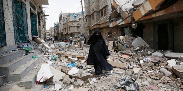 A woman walks amid the rubble of houses destroyed by a Saudi-led airstrike in Sanaa, Yemen, Monday, Sept. 21, 2015. Late Sunday night in Saudi Arabia's Jizan province, cross-border fire from Yemen's Shiite rebels has killed at least one foreigner and wounded many people, Saudi civil defense officials said. (AP Photo/Hani Mohammed)