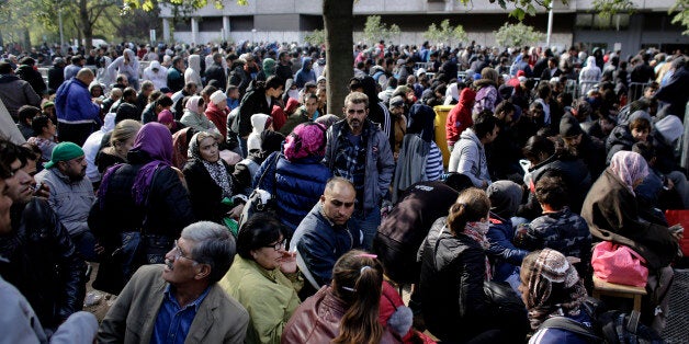 Hundreds of migrants and refugees wait for their registration at Berlin's central registration center for refugees and asylum seekers LaGeSo (Landesamt fuer Gesundheit und Soziales - State Office for Health and Social Affairs) in Berlin, Germany, Wednesday, Sept. 30, 2015. (AP Photo/Markus Schreiber)