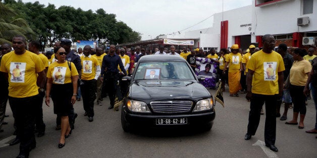 Angolan supporters of the opposition party Casa gather in the center of Luanda on November 27, 2013 to march to the cemetery and attend the funeral of a Casa militant. Nearly 1,000 mourners, mostly supporters of the opposition Casa party, converged in downtown Luanda for a funeral procession to a cemetery on the outskirts of the capital. Angolan police mobilised water cannons and helicopters to try to stop the funeral of opposition activist Hilbert Ganga, killed by security services at the weekend. AFP PHOTO / ESTELLE MAUSSION (Photo credit should read ESTELLE MAUSSION/AFP/Getty Images)