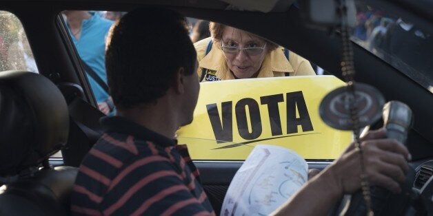 CARACAS - VENEZUELA, DECEMBER 3: A woman holds a banner depicting the word VOTE at a campaign rally for opposition candidates in Caracas, Venezuela, on Thursday, Dec. 3, 2015. Venezuelans head to the polls on Dec. 6 to vote in congressional elections. (Photo by Carlos Becerra/Anadolu Agency/Getty Images)