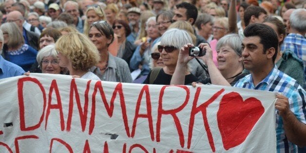 COPENHAGEN, DENMARK - AUGUST 26: People hold banners during a protest in support of the refugees in Copenhagen, Denmark on August 26, 2015. More than 5,000 people gathered in Copenhagen protested the government policy against refugees. (Photo by Recep Yasar /Anadolu Agency/Getty Images)