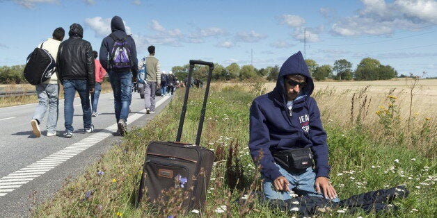 A migrant prays beside a freeway north of Rodby as a large group of migrants, mainly from Syria, walk on the highway towards the north September 7, 2015. Many migrants, mainly from Syria and Iraq, have arrived in Denmark over the last few days. The migrants want to reach Sweden to seek asylum there. Some of the migrants arriving in central Europe have continued on to other countries, as local authorities across the continent try to accommodate the rising tide of refugees. Picture taken September 7, 2015. REUTERS/Jens Norgaard Larsen/Scanpix ATTENTION EDITORS - THIS IMAGE WAS PROVIDED BY A THIRD PARTY. FOR EDITORIAL USE ONLY. NOT FOR SALE FOR MARKETING OR ADVERTISING CAMPAIGNS. THIS PICTURE IS DISTRIBUTED EXACTLY AS RECEIVED BY REUTERS, AS A SERVICE TO CLIENTS. DENMARK OUT. NO COMMERCIAL OR EDITORIAL SALES IN DENMARK. NO COMMERCIAL SALES.