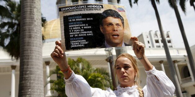 Lilian Tintori, wife of jailed opposition leader Leopoldo Lopez, holds a sign with a picture of him as she attends a session of the National Assembly in Caracas, February 4, 2016. Local media report that a draft amnesty law for jailed politicians and activists will be on Thursday?s National Assembly agenda. REUTERS/Carlos Garcia Rawlins