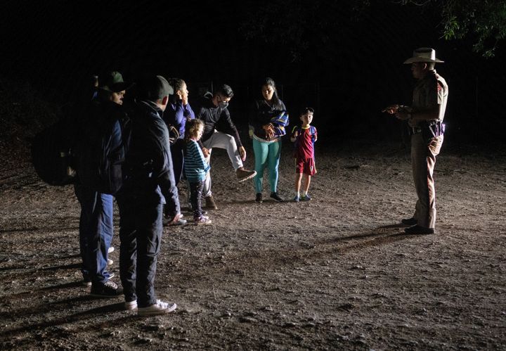 A Texas state trooper advises Venezuelan immigrants to remove their shoelaces before they are taken into custody by U.S. Border Patrol agents on May 19 in Del Rio, Texas.