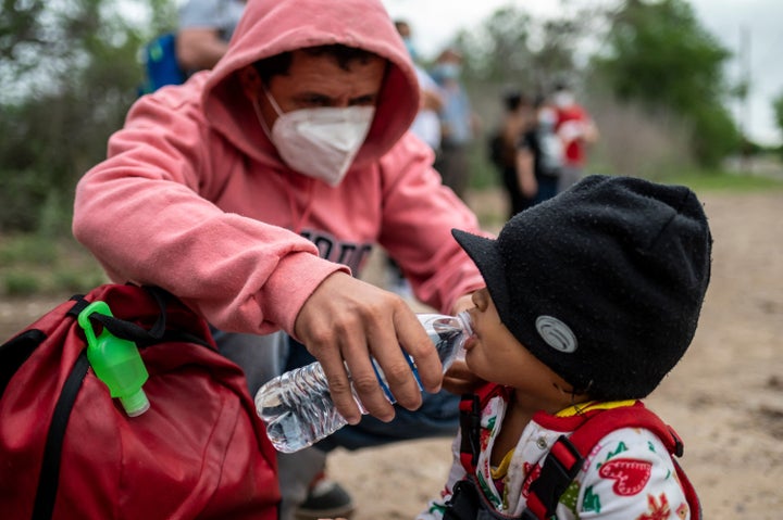 Nelson Alexsi Portillo Guillen gives his 2-year-old daughter Maria Amparo a drink of water after being apprehended near the b