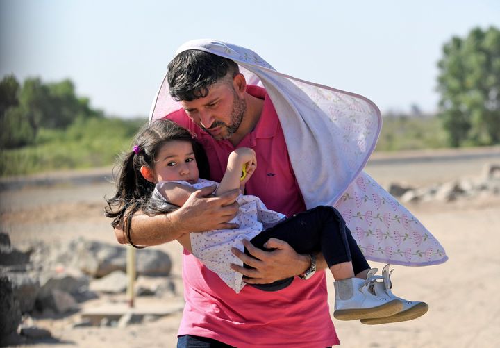 Luis Sarcos from Venezuela holds his daughter Luna as they attempt to cross into the U.S. from Mexico on June 4 in San Luis, Arizona.