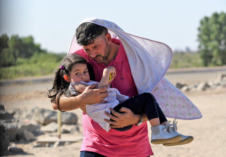 Luis Sarcos from Venezuela holds his daughter Luna as they attempt to cross into the U.S. from Mexico on June 4 in San Luis, Arizona.