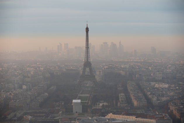 La Tour Eiffel et le quartier d'affaires de La Défense entourés de hauts niveaux de pollution atmosphérique sont vus au coucher du soleil le 7 décembre 2016 à Paris. La région parisienne avait connu le pic de pollution hivernal le plus long et le plus intense depuis dix ans, selon Airparif. (Photo by Chesnot/Getty Images)
