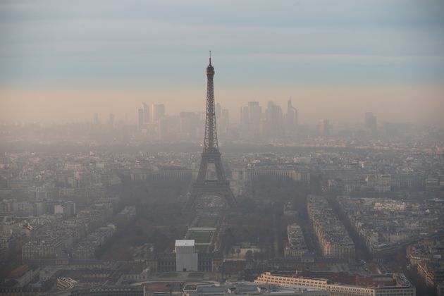 La Tour Eiffel et le quartier d'affaires de La Défense entourés de hauts niveaux de pollution atmosphérique sont vus au coucher du soleil le 7 décembre 2016 à Paris. La région parisienne avait connu le pic de pollution hivernal le plus long et le plus intense depuis dix ans, selon Airparif. (Photo by Chesnot/Getty Images)