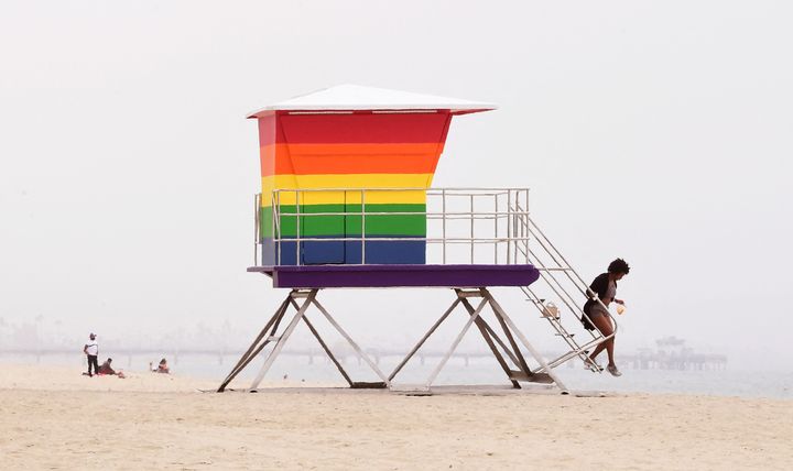 A woman steps off the stairs of a rainbow-colored lifeguard tower in Long Beach, California, on June 16. California has prohibited state travel to 17 states because of laws that discriminate against members of the LGBTQ community.