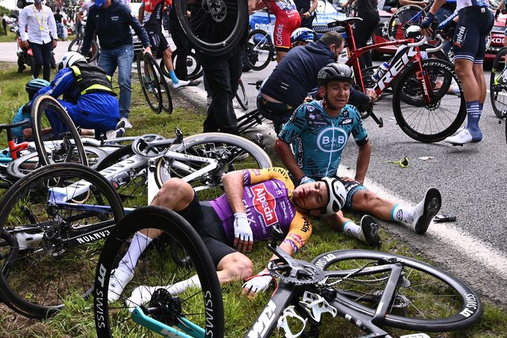 Two cyclists lie on the ground after crashing during the 1st stage of the 108th edition of the Tour de France cycling race on Saturday.
