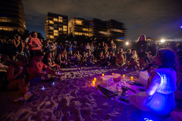 People attend a community vigil on the beach for those missing.