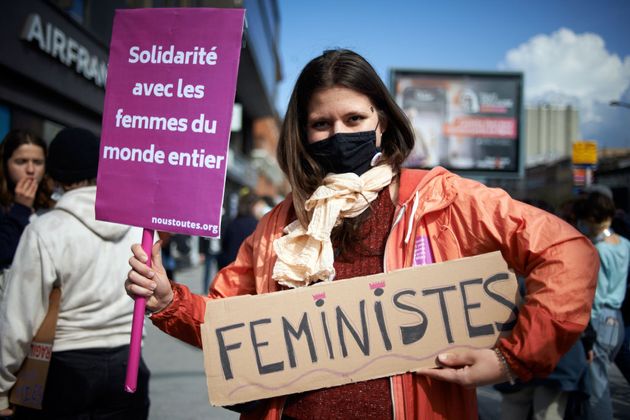 Une manifestante tient une pancarte sur laquelle on peut lire 