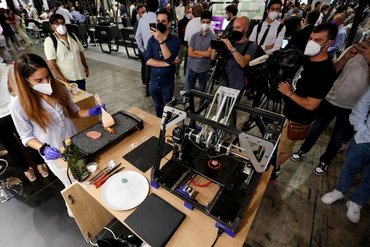 Μια γυναίκα μαγειρεύει ένα κομμάτι «κρέας» που εκτυπώθηκε με έναν 3D εκτυπωτή από τη Novameat στο Mobile World Congress στη Βαρκελώνη,