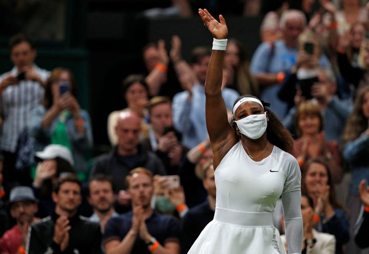 Serena Williams waves goodbye after withdrawing from the match at Wimbledon.