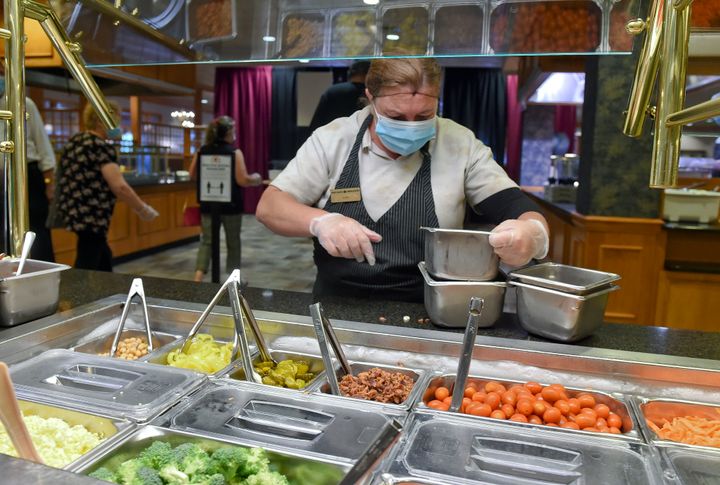 An employee restocks the salad bar at the Shady Maple Smorgasbord in Pennsylvania, which reopened last summer with certain modifications and precautions in place after being closed toward the beginning of the COVID-19 outbreak.