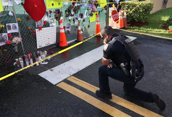 Miami Beach Police Officer David Cajuso prays before a memorial set up near the partially collapsed 12-story building on Wedn