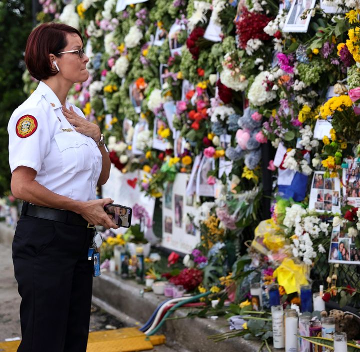 Miami-Dade Fire Rescue Chief Melanie C. Adams visits the makeshift memorial setup near the partially collapsed 12-story Champlain Towers South Condo in Surfside, Fla., Thursday, July 1, 2021. (David Santiago /Miami Herald via AP)