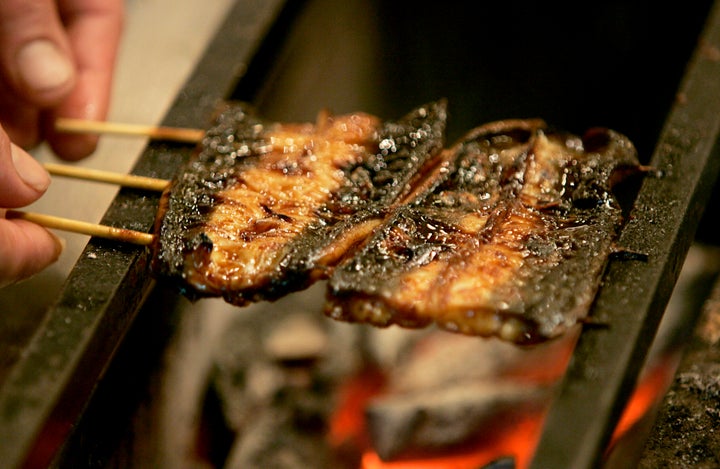 Japanese eels are cooked over charcoal at an eel restaurant 'Yaotoku' in Tokyo July 26, 2007. Many Japanese eat vitamin-rich eel in summer to bolster their stamina after days of heat-enervated appetites, especially so on Eel Day -- formally known as "Doyo no Ushi no Hi" -- on July 30, a date determined by the ancient solar calendar and believed to be the hottest of the year. Eel aficionados -- who devour broiled eels in a bid to beat the heat -- are opting for pricey domestic eels over cheap Chinese imports amid food safety fears. REUTERS/Yuriko Nakao (JAPAN)