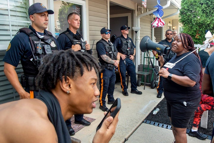 Shanta Smith, right, confronts police outside Mathews’ home on Monday. Mathews was filmed Friday confronting a Black neighbor, pushing him with his chest and using racist slurs.