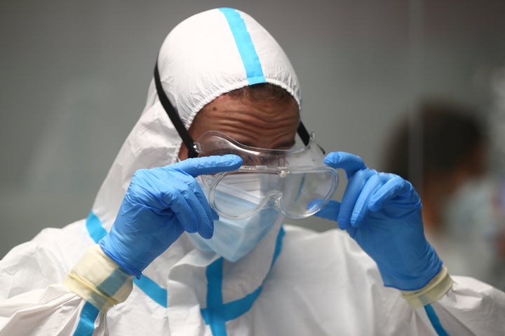 Un sanitario se ajusta su equipo de trabajo.