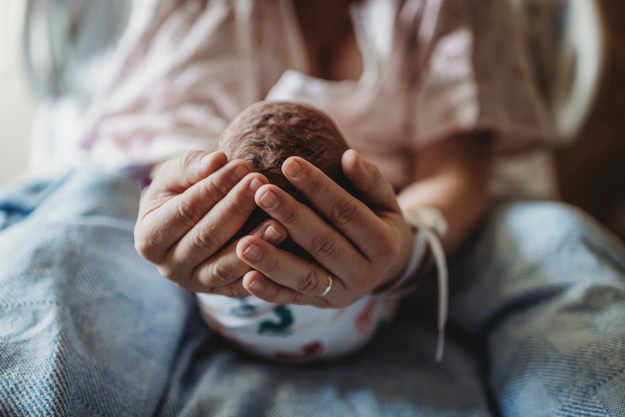 Un bebé en las manos de su madre.