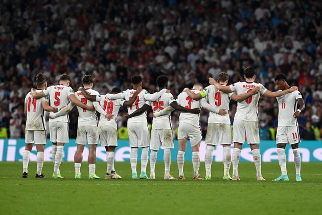 Players of England watch from the halfway line during the penalty shoot out.