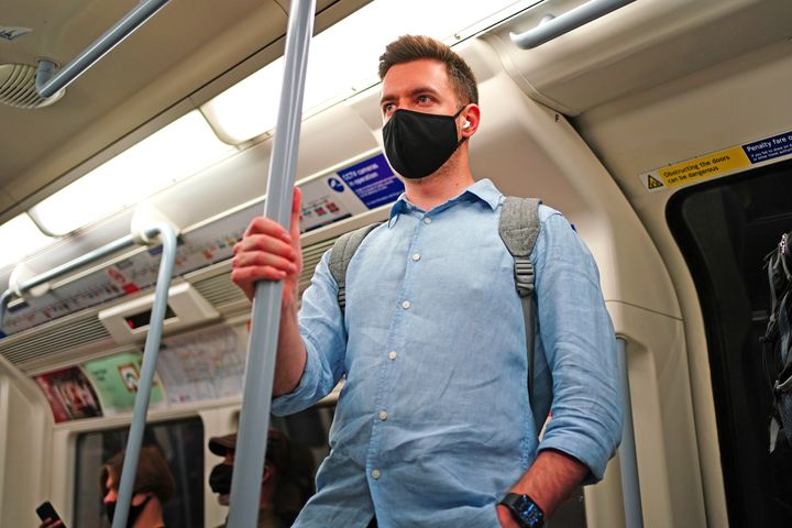 A man wearing a facemask on an underground tube train in central London, during the easing of lockdown restrictions in England. 