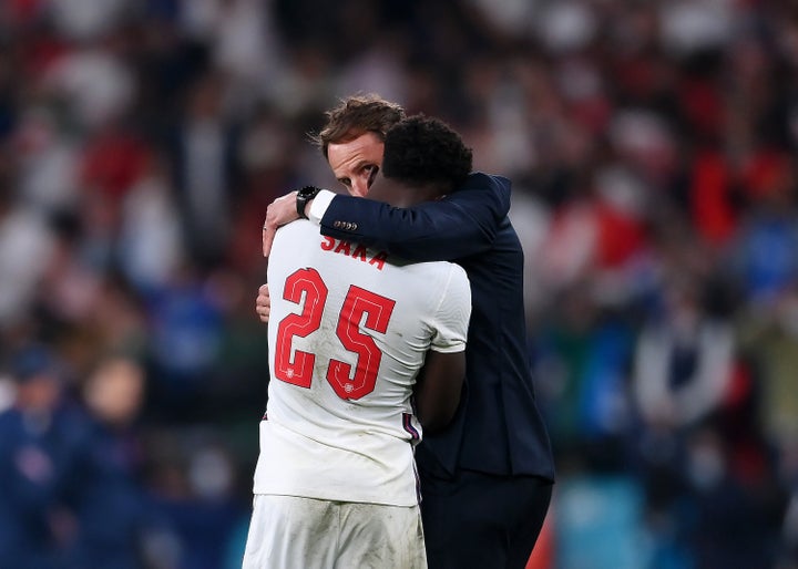 Bukayo Saka of England is consoled by head coach Gareth Southgate after his penalty miss during the UEFA Euro 2020 Championship Final between Italy and England at Wembley Stadium on July 11, 2021, in London, England.