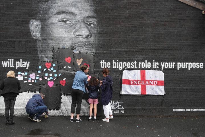 Μάντσεστερ 12 Ιουλίου 2021. Περαστικοί τοποθετούν μηνύματα αγάπης και υποστήριξης στο γκράφιτι όπου εικονίζεται ο ποδοσφαιριστής της Μάντσεστερ Γιουνάϊτεντ και της Εθνικής Αγγλίας Μάρκους Ράσφορντ, ο οποίος έγινε στόχος ρατσιστών επειδή αστόχησε σε ένα πέναλτι στον τελικό του EURO 2020 ανάμεσα στην Αγγλία και στην Ιταλία. (Photo by Christopher Furlong/Getty Images)