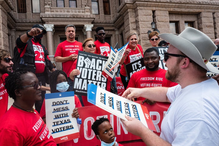 "Don't Mess With Texas Voters" signs are distributed before the start of a voting rights rally outside of the Texas State Capitol on July 8 in Austin, Texas.