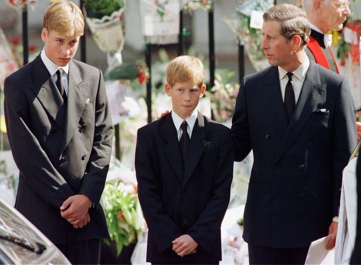 Prince Charles puts his hand on Prince Harry's shoulder as Prince William looks on after the coffin of Diana, Princess of Wal