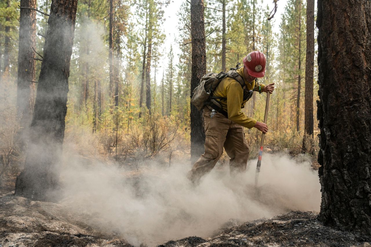 Firefighter Garrett Suza, with the Chiloquin Forest Service, mops up a hot spot on the North East side of the Bootleg Fire.